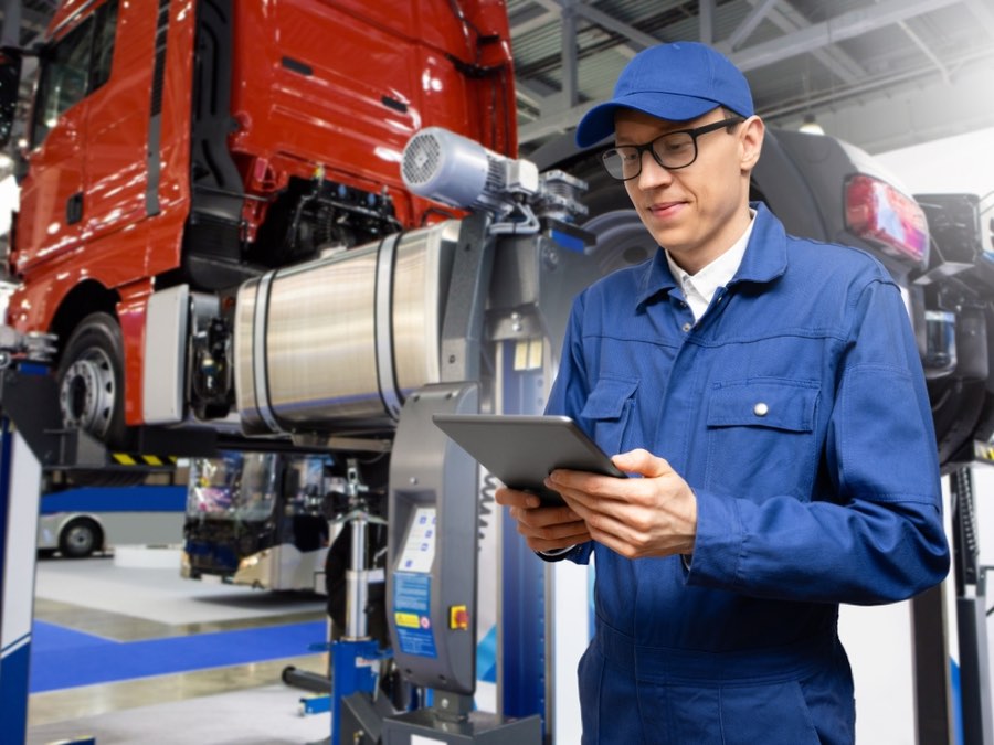 Tecnico CBS al lavoro su un veicolo industriale sollevato