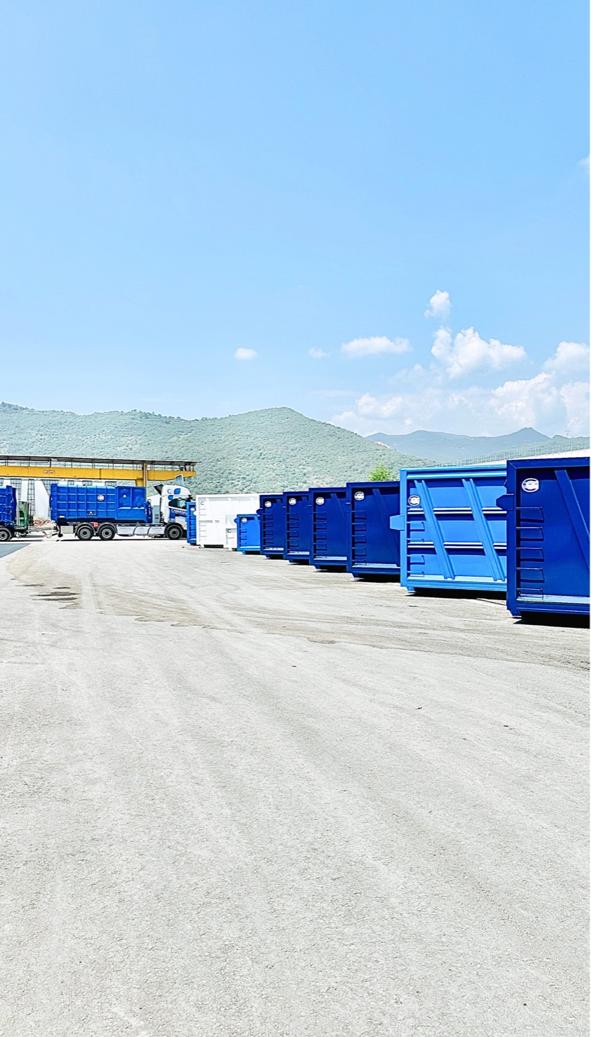 Container scarrabili blu e mezzo allestito nel piazzale dello stabilimento